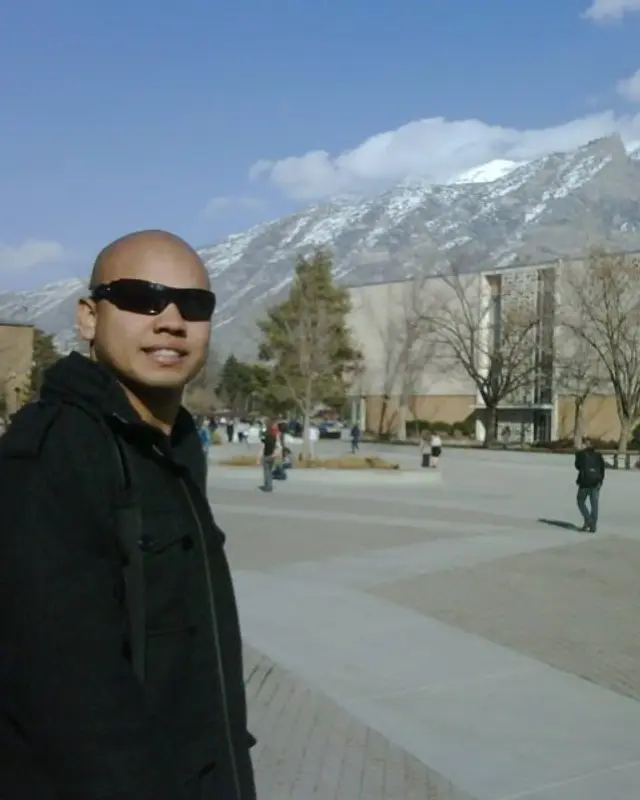 Rodrigo no campus da BYU, com a montanha nevada atrás